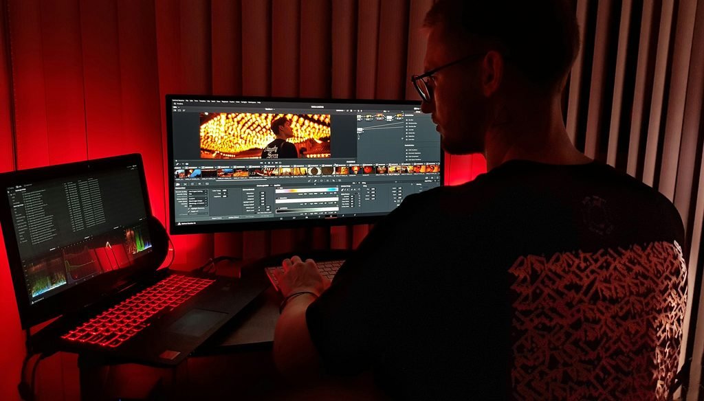 a man editing a video on two laptops